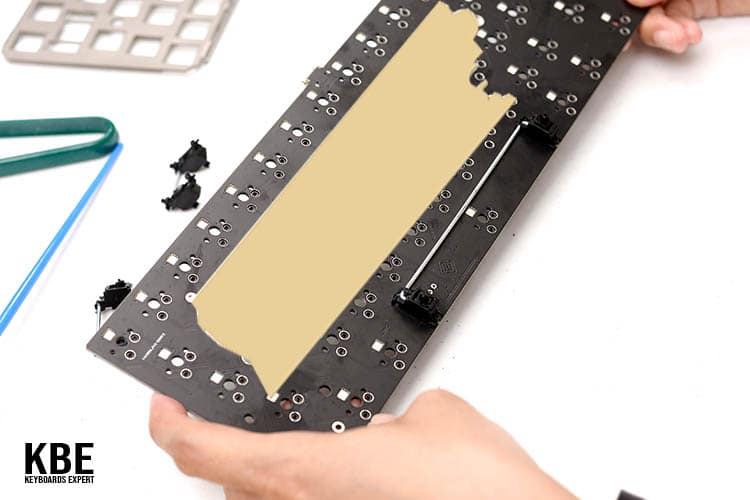 Hand with PCB and tape with keyboards expert logo cover