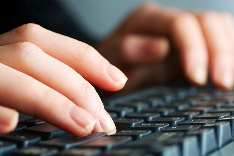 Female hands typing on computer keyboard